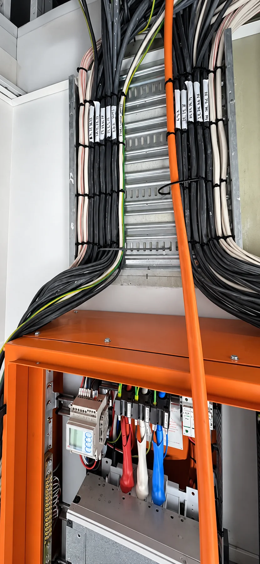 Organised electrical cabling entering a distribution board
