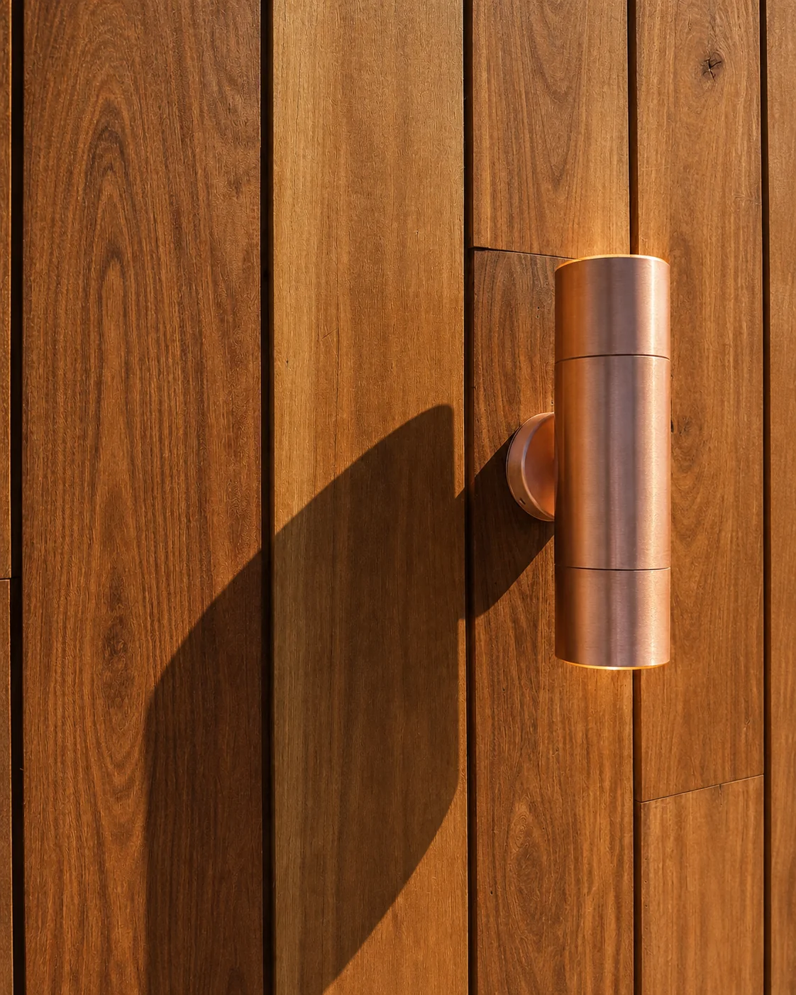 Copper coloured outdoor wall light on timber cladding